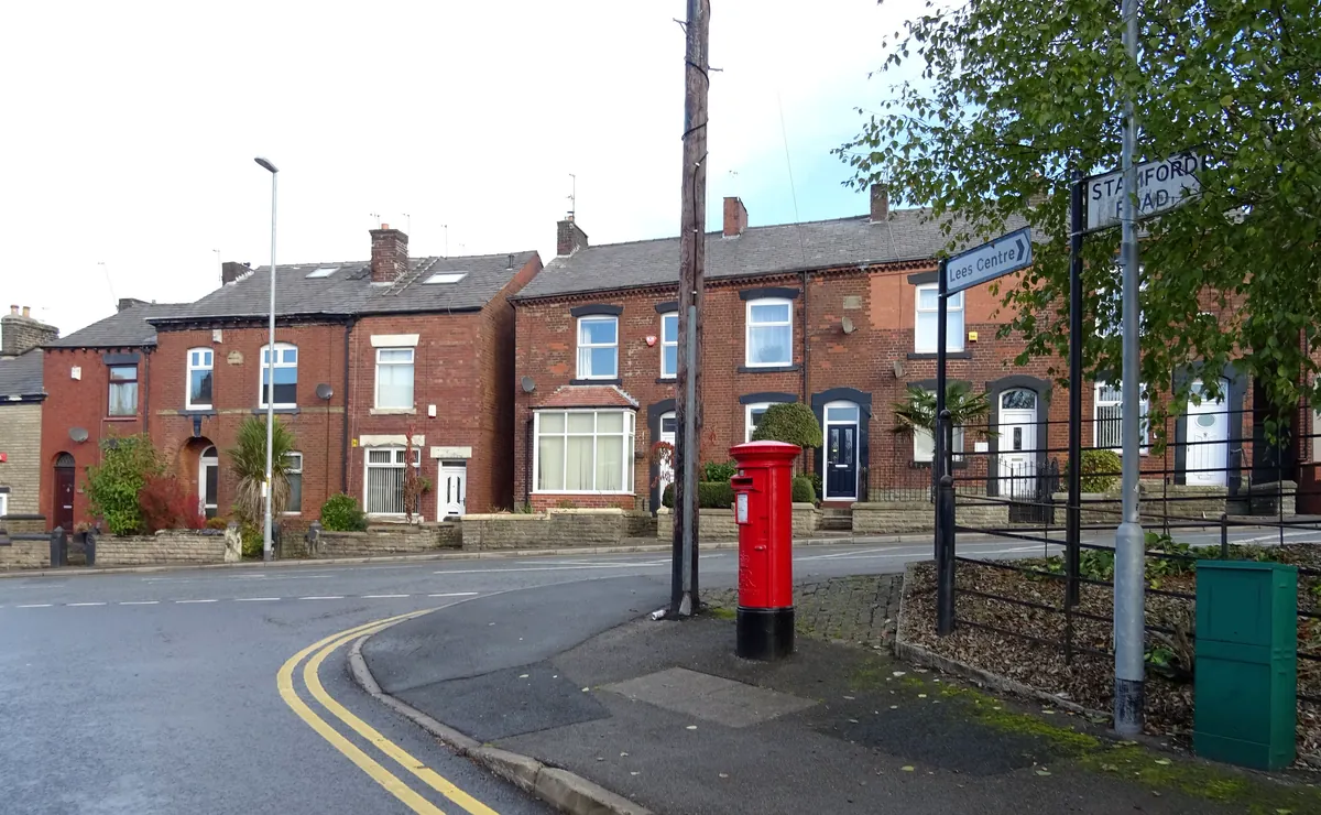 Red-brick terraced houses with bay windows on Huddersfield Road in Lees